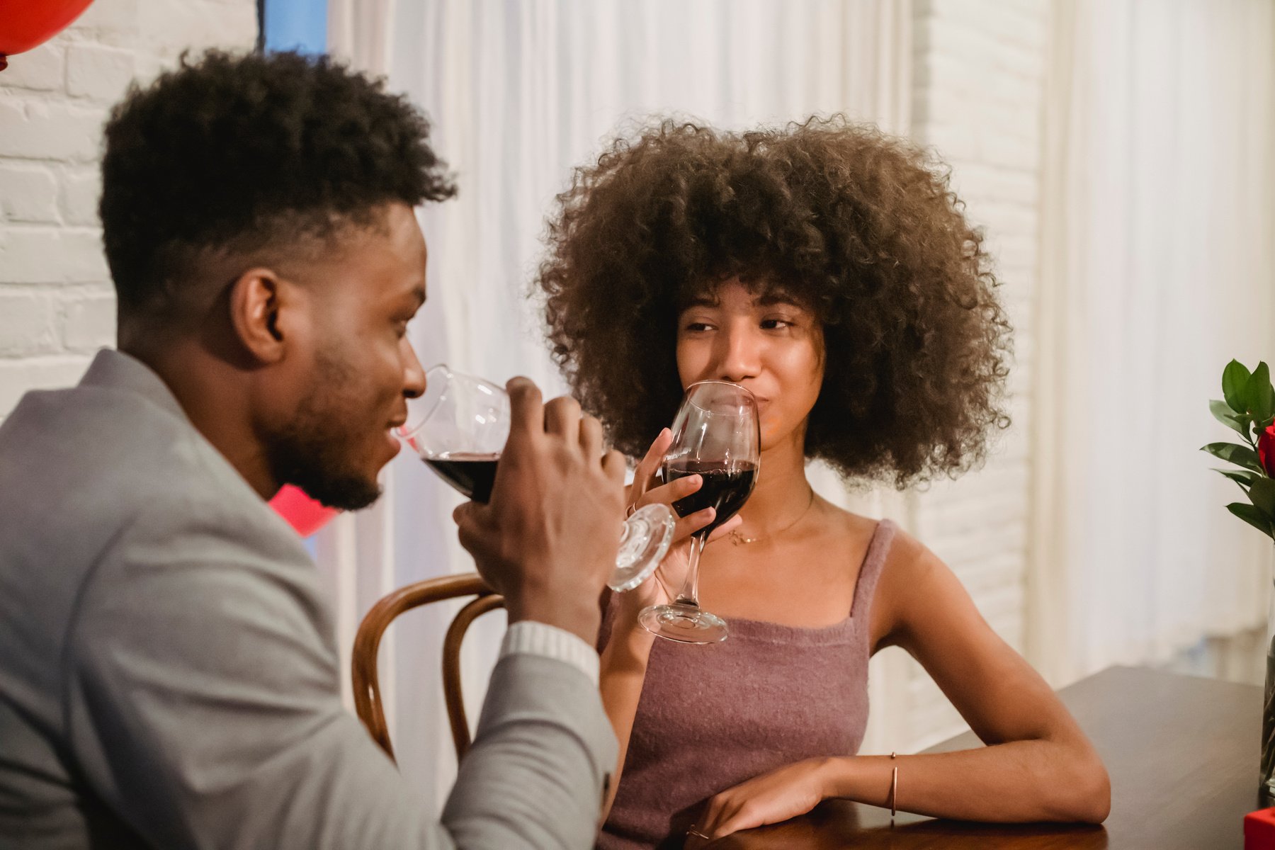 Black couple drinking wine while having date at table